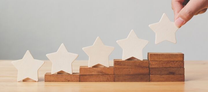 Fünf Sterne, die auf stufenweise immer höher auf Holzblöcke gestellt werden