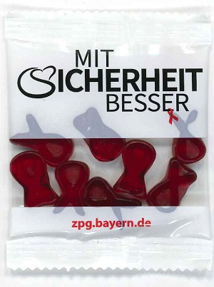 Fruchtgummi in Form von AIDS-Schleife in Tüte mit Aufschrift "Mit Sicherheit besser"