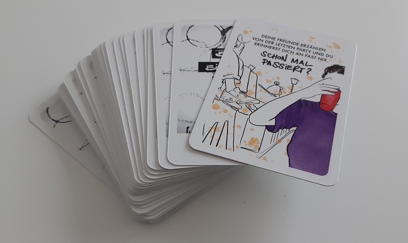 Spielkarten mit unterschiedlichen Illustrationen, Sprüchen und Fragen